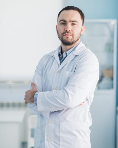 Young handsome doctor indoors at hospital office.